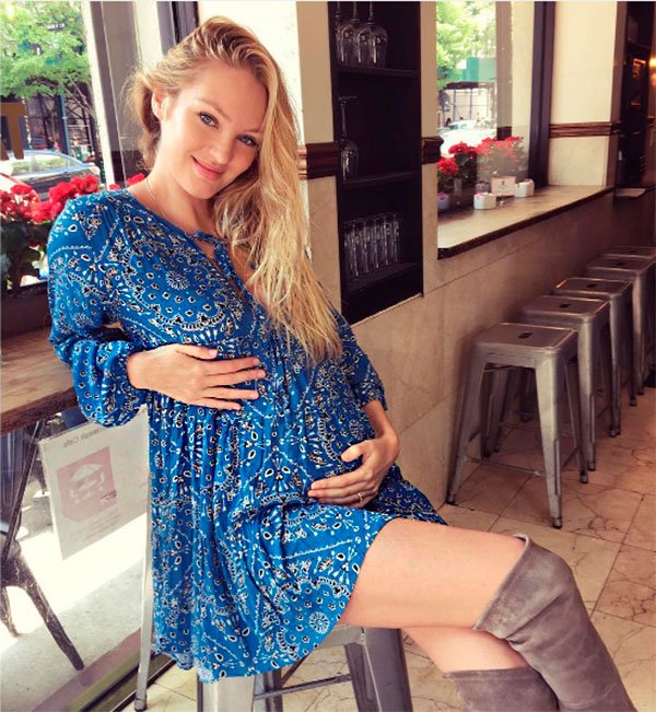 Candice Swanepoel grávida usa vestido azul com bota over the knee marrom