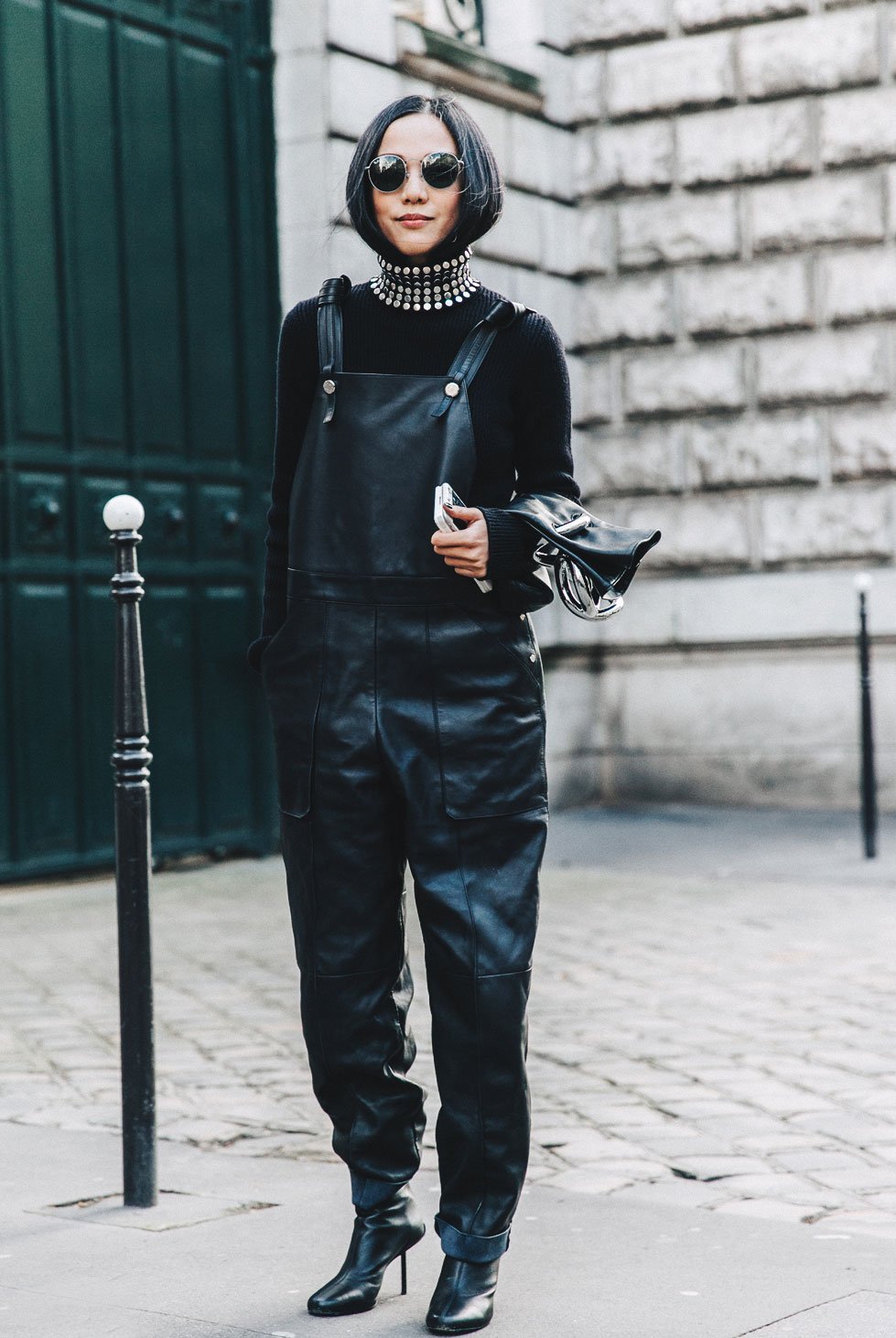 Street style mostra como usar macacão de couro no inverno com blusa de manga longa preta e gola