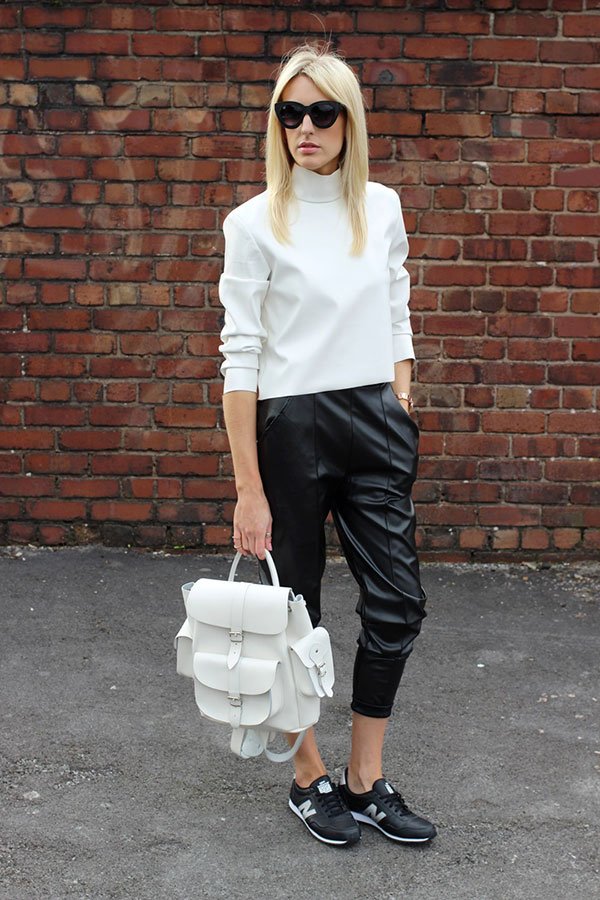 Street style com looks usando tenis new balance mais mochila de couro branco
