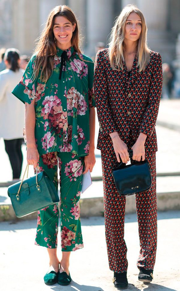 Mulheres posam para foto de street style vestindo conjuntos estilo pijama, um estampado com triângulos vinho e o outro com fundo verde e floral