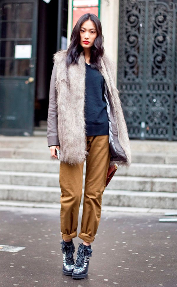 Street style look com colete de pêlo fake cinza, calça marrom e sapato preto.