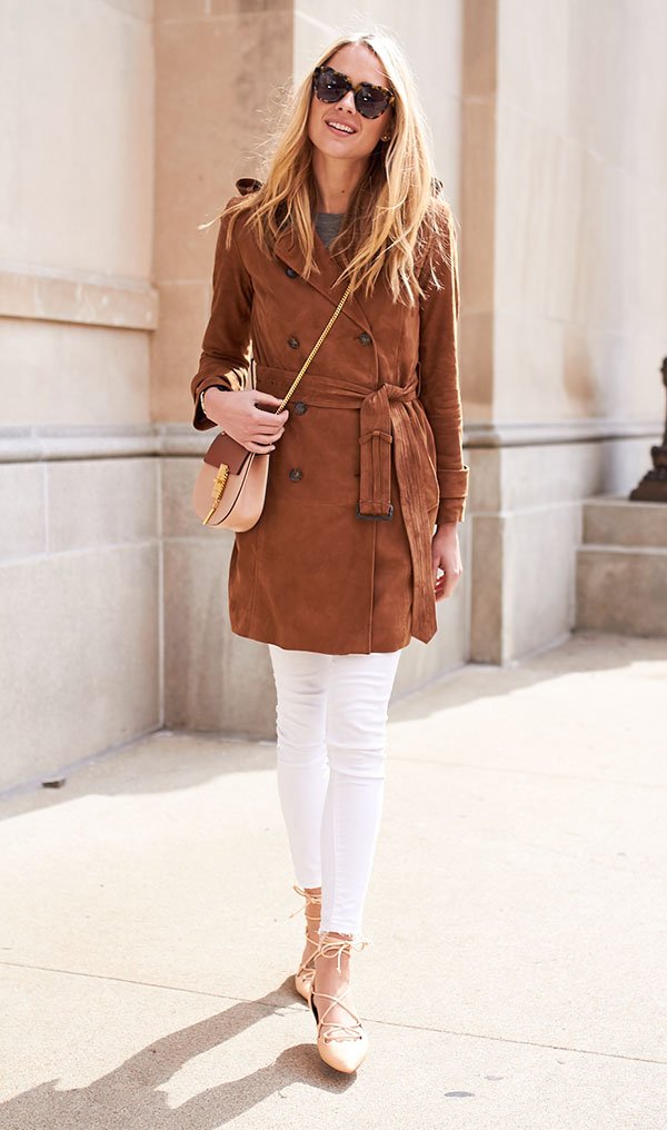 street style look com mulher loira usando sobretudo marrom de camurça, calça jeans branca e sapato amarração nude