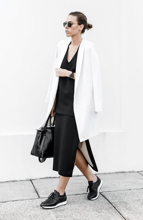 Kaitlyn Hamstyle com look de vestido preto e blazer branco oversizes, tênis de couro preto e bolsa preta