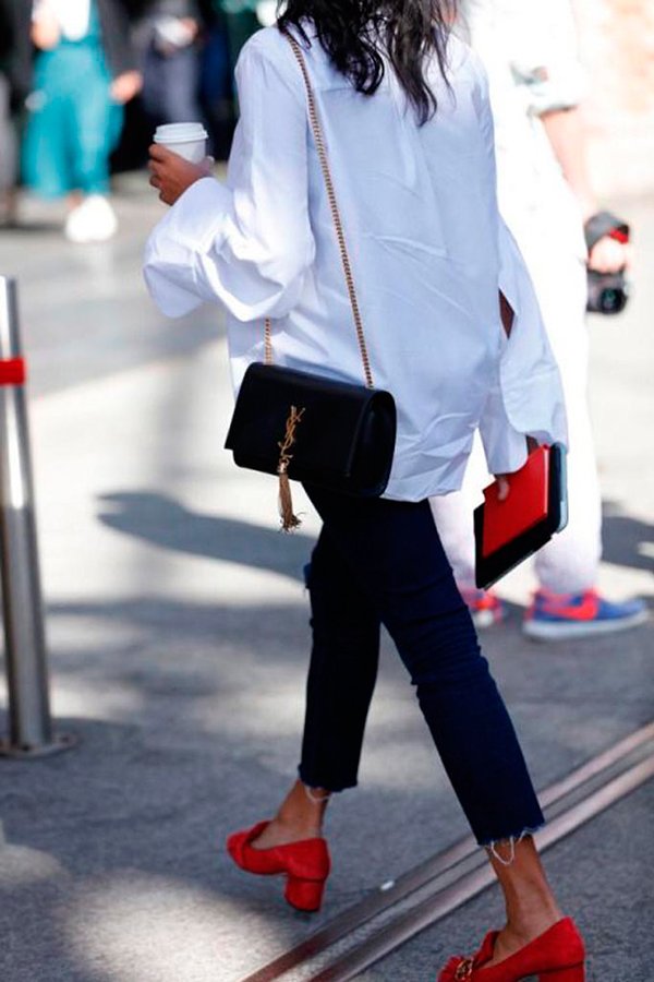 Street style de camisa branca oversized, calça skinny cropped, sapatos vermelhos e bolsa de alça de corrente