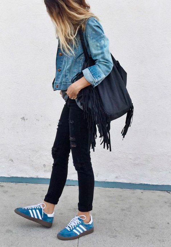Street style de look com jaqueta jeans, calça jeans destroyed preta e tênis adidas gazelle azul