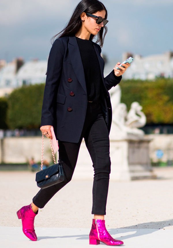 Street style look com blusa e calça preta, blazer azul oversized e bota glitter rosa.