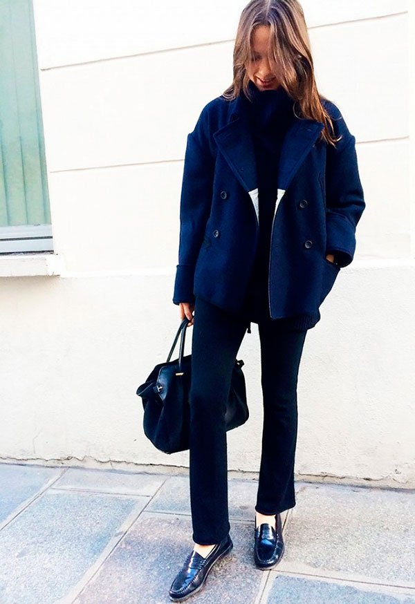 Street style look Columbine Smille com turtleneck preta, calça preta, sapato boyish e casaco azul.