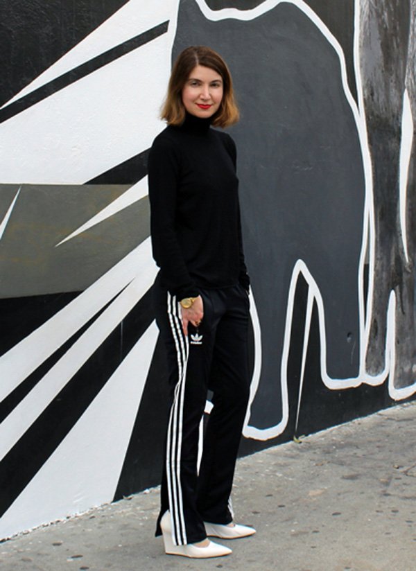 Street style look suéter preto, calça preta adidas e salto branco.
