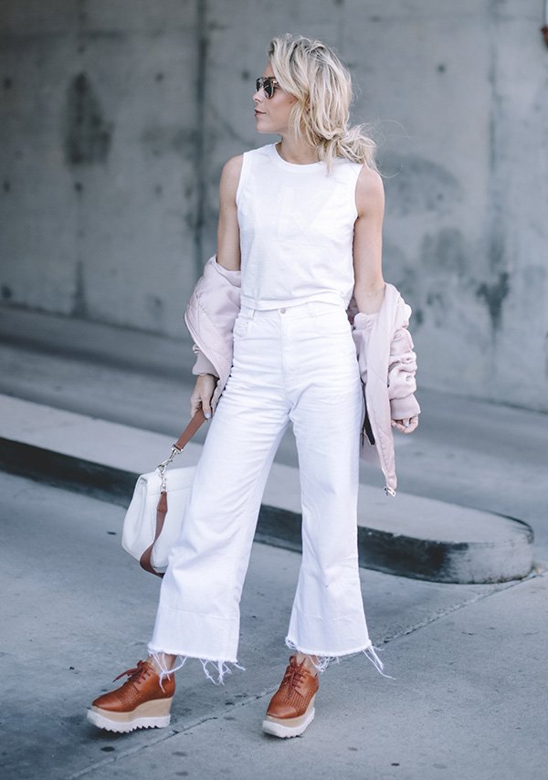 Street style look blusa branca, calça cropped, jaqueta rosa e sapato tratorado.