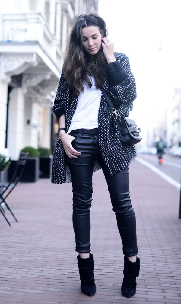 Street style look com camiseta branca, calçca preta couro, ankle boot e casaco preto e branco