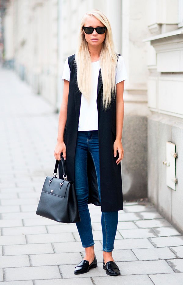 Street style look com colete longo preto, camiseta tshirt branca, calça jeans e sapato boyish preto.
