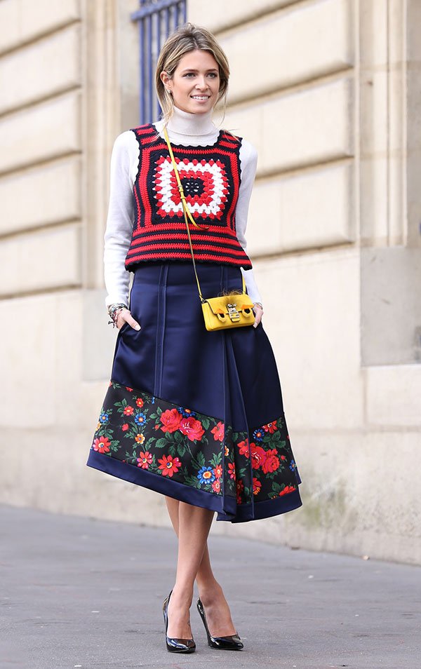 Street style look Helen Bordon com colete de crochet colorido, blusa manga longa gola branca, saia midi  e scarpin preto.