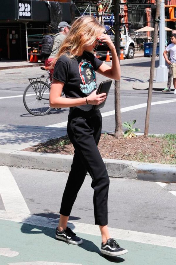 Street style look Gigi Hadid com tênis Vans, calça preta e tshirt.