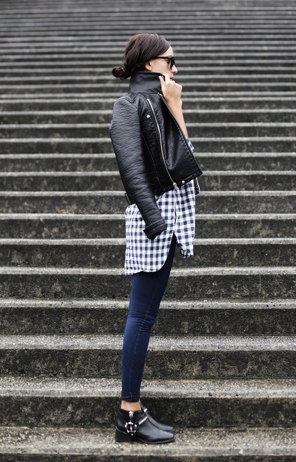 Street style look camisa xadrez, jaqueta couro, calça jeans e bota com fivela preta.