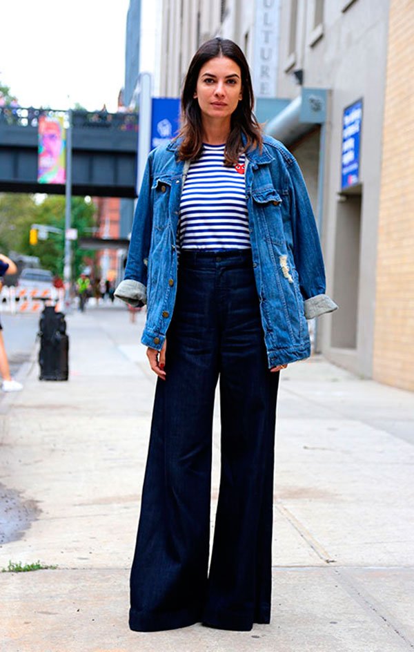 Street style look jaqueta jeans, blusa listrada e calça pantalona.