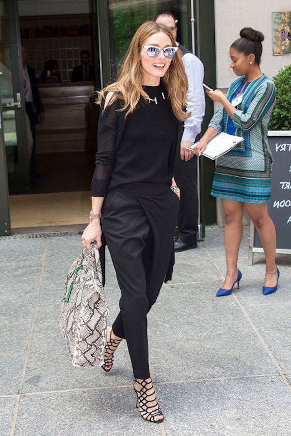 Street style look Olivia Palermo com look todo preto, bolsa animal print cobra e sandália Schutz.