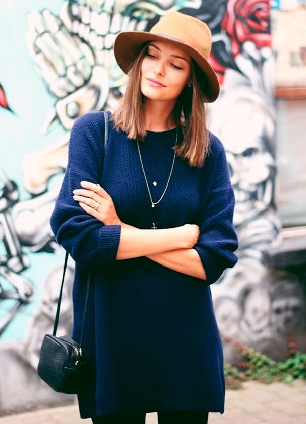 street sttyle look sueter azul, calça preta e chapéu bege.