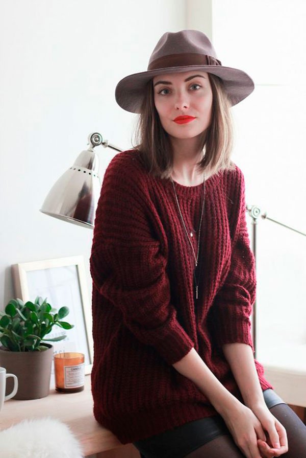 Street style look suéter vermelho burgundy, saia preta couro, meia calça e chapéu marrom.