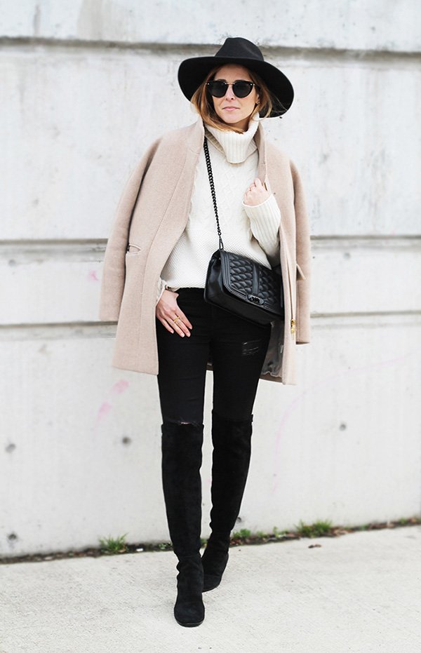 Street style look suéter bege, calça jeans, bota over the knee e chapéu.