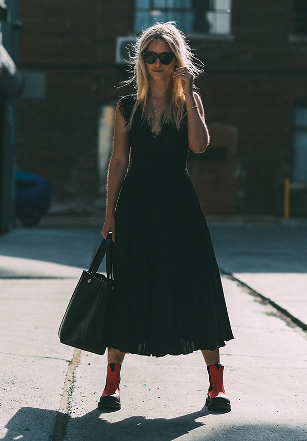Street style look com vestido midi preto e bota cano baixo.
