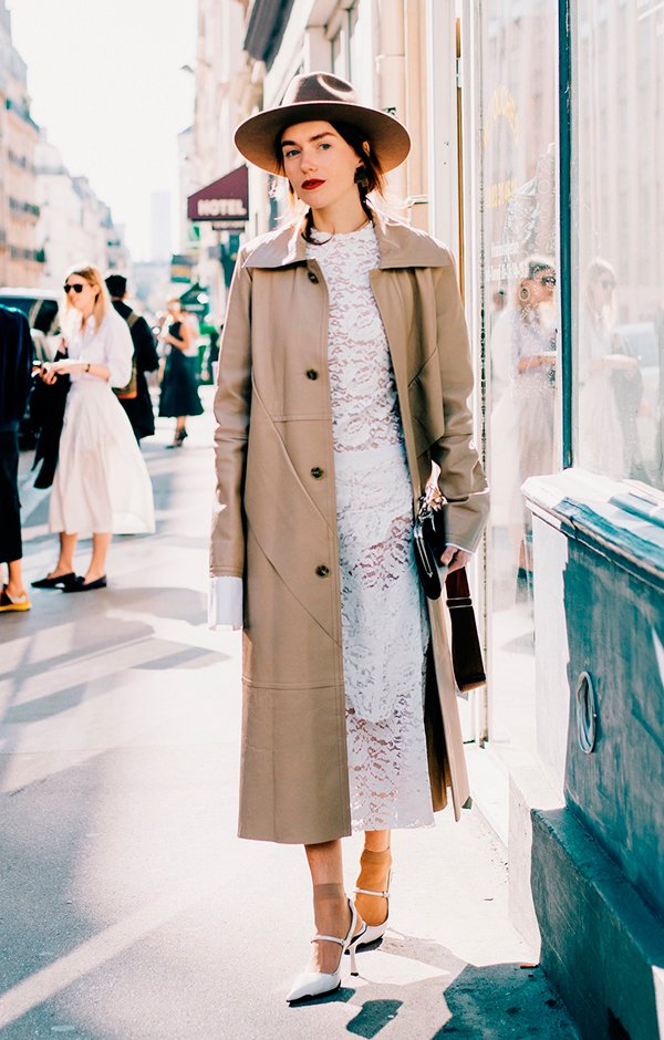 Foto de Street Style de look misturando estilos diferentes como vestido branco de renda e trench coat nude, com chapéu e scarpin branco