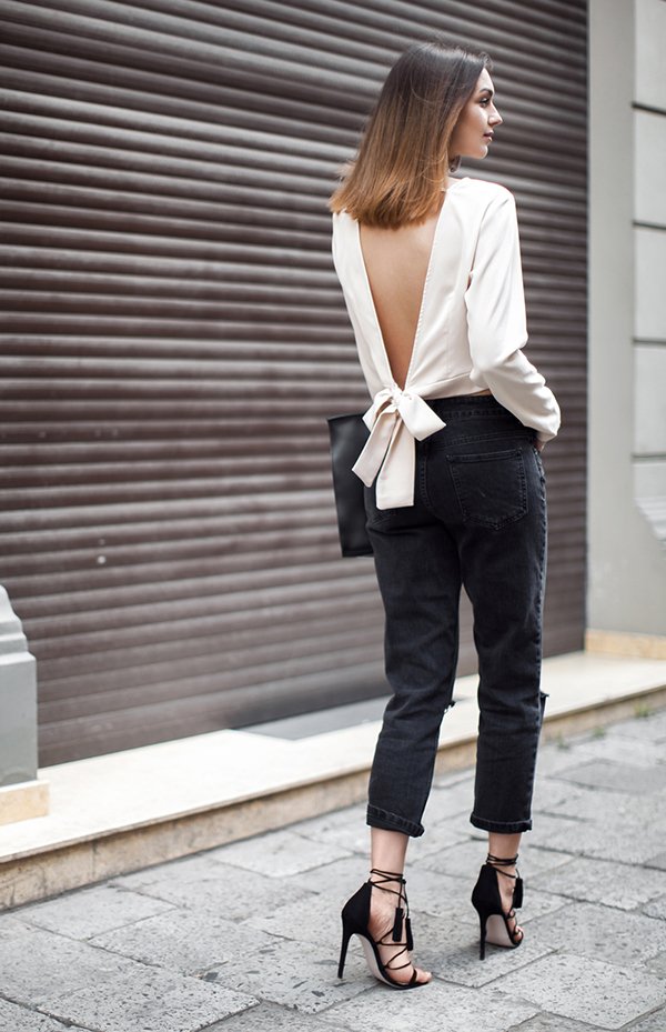 Foto de street style com blusa off white com decote nas costas, calça de alfaiataria preta cropped e salto alto