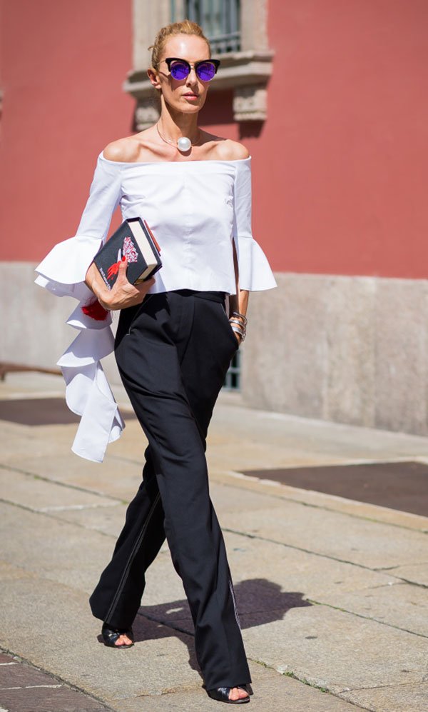 Street style look com blusa ombro a ombro, calça social e óculos espelhado roxo.