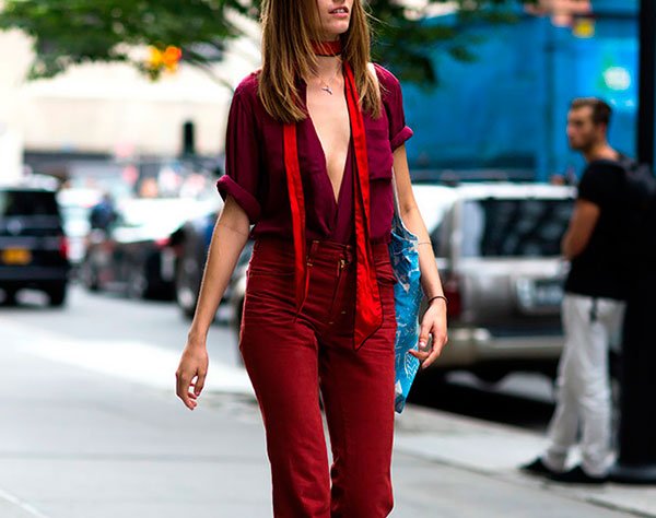 Street style look com skinny scarf, camisa decotada e calça burgundy.