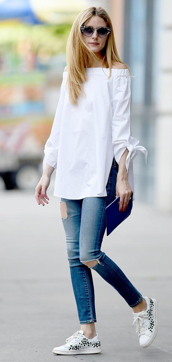 Street style look com blusa branca off shoulder, jeans e tênis branca.