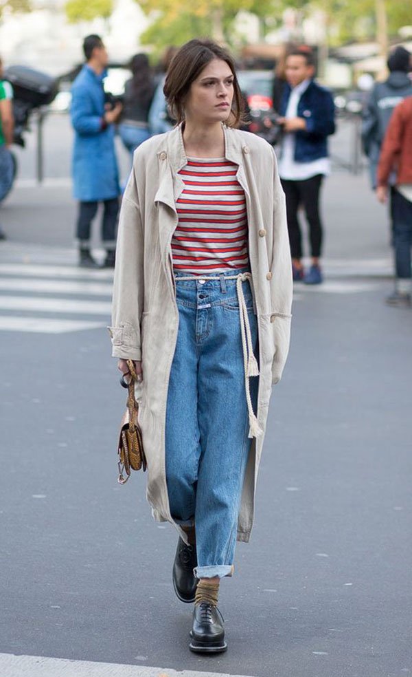Street style look com sobretudo bege, calça jeans, e sapato boyish.
