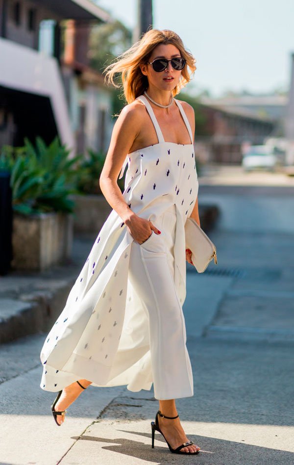 Street style look com vestido fenda, calça branca e sandália tiras.