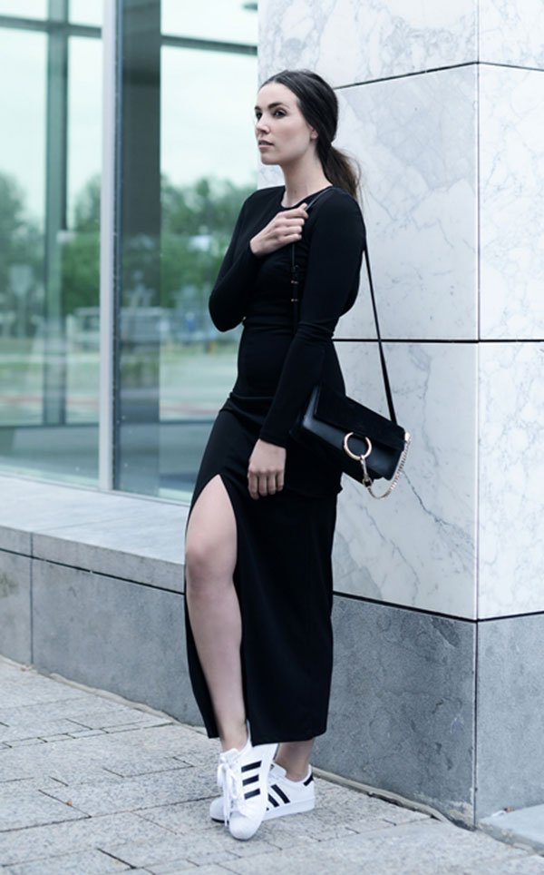 Street style look com vestido preto fenda manga longa e tênis branco Adidas.