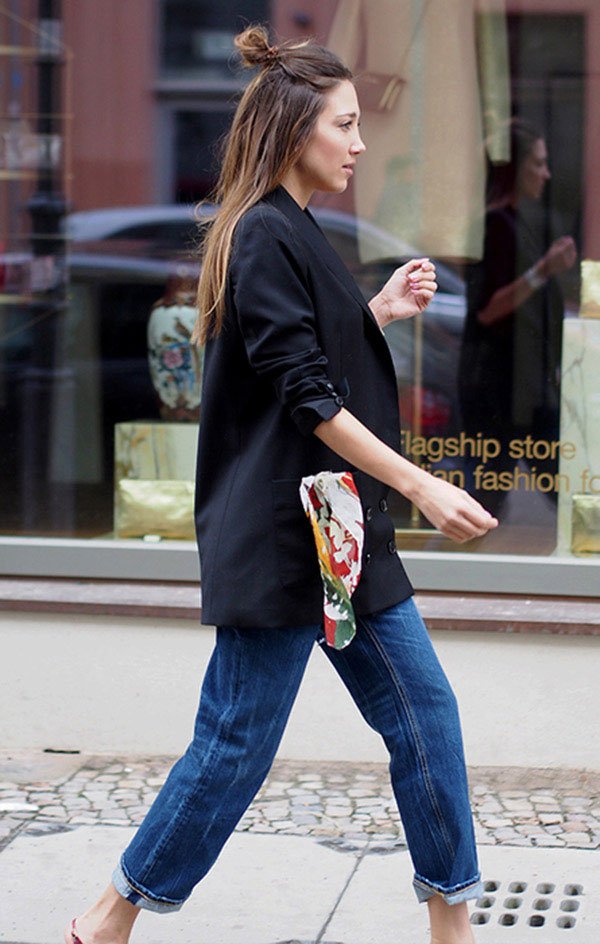 Street style look com blazer arregaçado na manga e calça jeans.