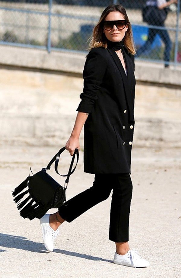 Street style look total black com bolsa franjas e tenis branco.