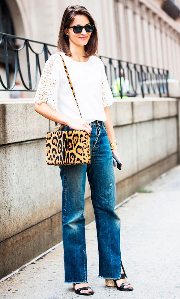 Street style look com blusa rendada, bolsa animal print e calça jeans.