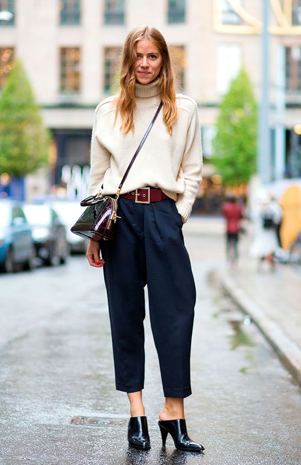 Street style look com suéter bege, calca azul cropped.