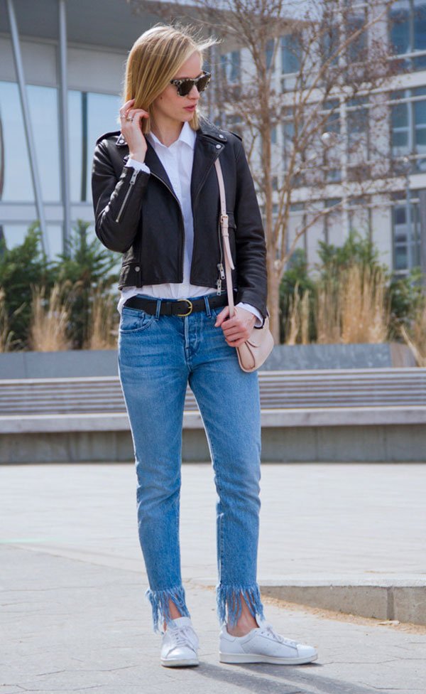 Street style look com calça jeans, jaqueta de couro e tênis.