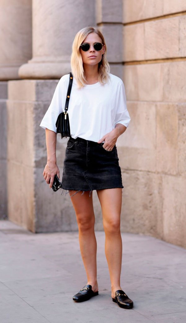 Street style look com camiseta branca, saia jeans e mule.