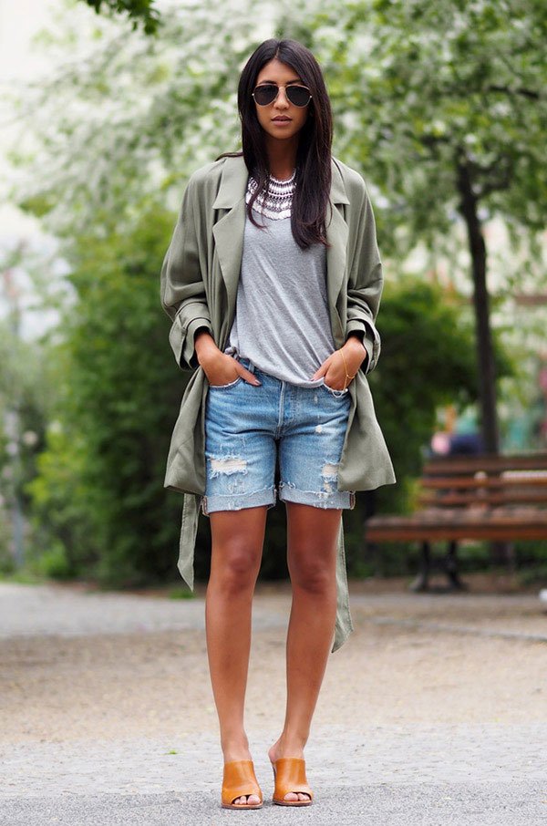 Street style look com shorts jeans, camiseta cinza e casaco verde.