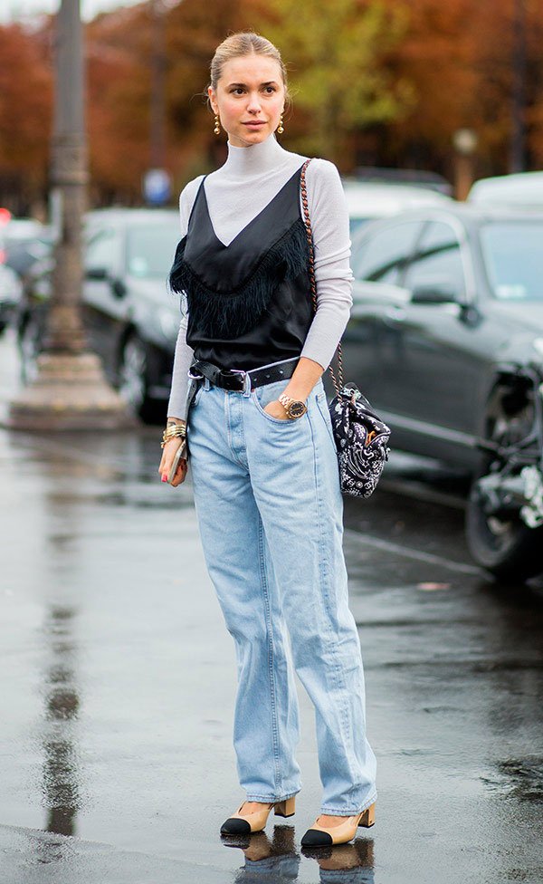 Street style look com sobreposição de regata com blusa e calça jeans.
