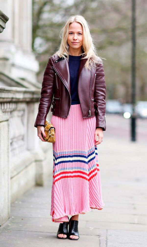 Street style look com saia plissada rosa, jaqueta curo marrom e mule.