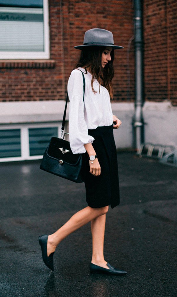 Street style look com camisa branca, saia social, chapéu e sapatilha.