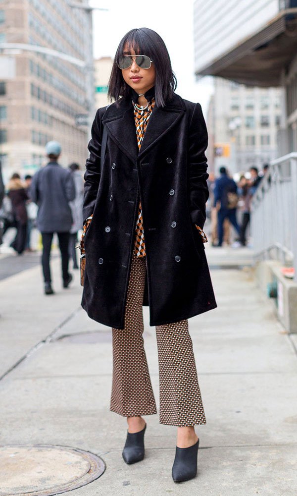 Street style look casaco preto, calçca cropped estampada e mule.
