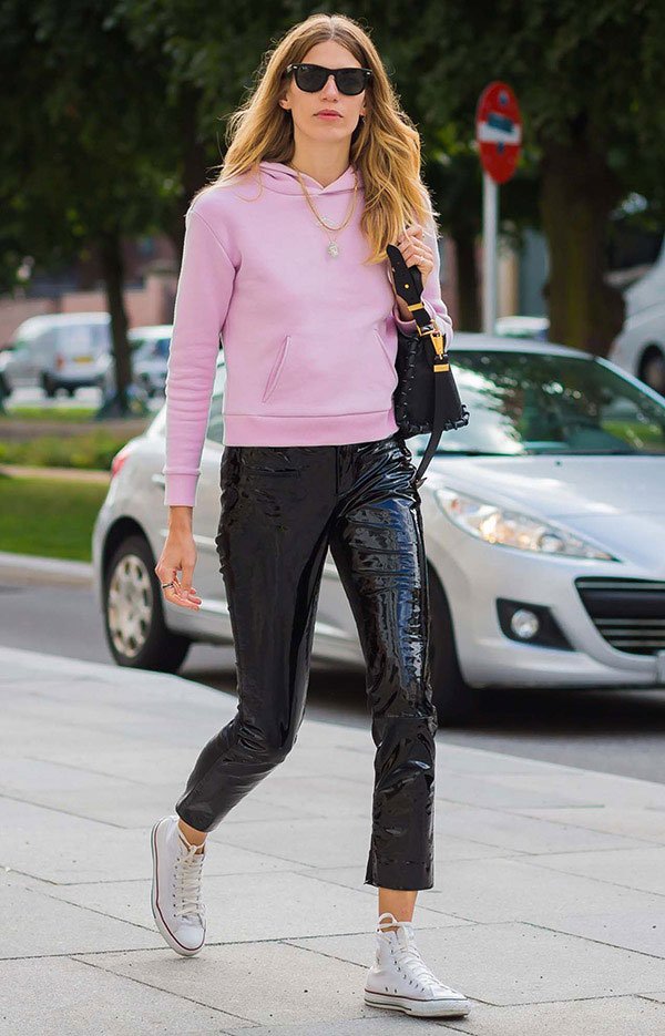Street style look com moletom rosa e calça de verniz.