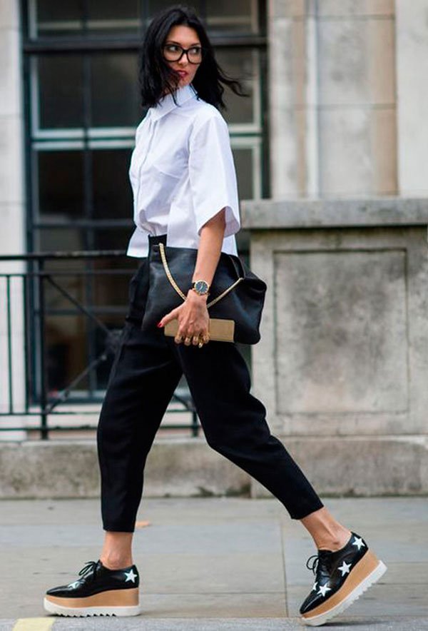 Street style look com camis branca e calça preta.