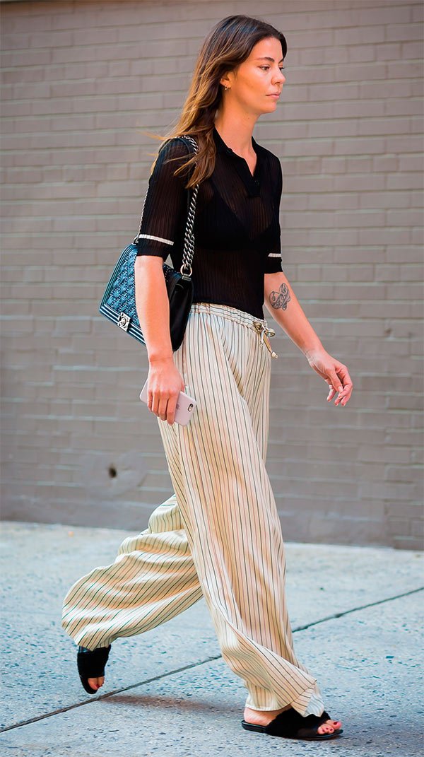 Street style look com blusa polo e calça listrada.