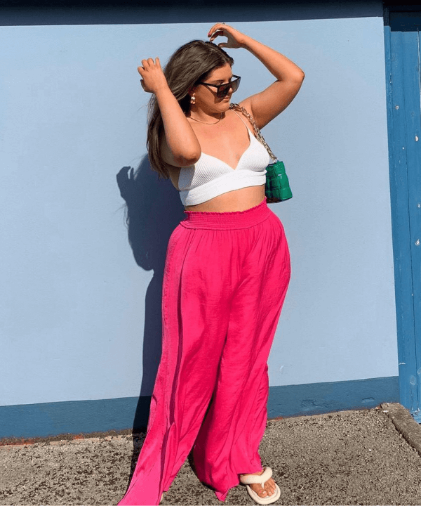 Phoebe Martha Evans - calça rosa, cropped branco e chinelo - looks novos - verão - em pé na rua - https://stealthelook.com.br
