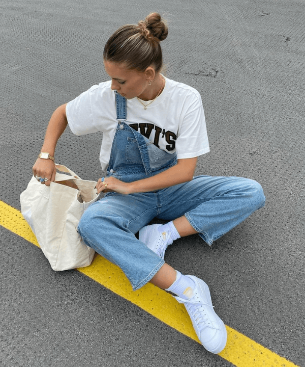 Mia Dickerson - macacão jeans, t-shirts e tênis branco - looks novos - verão - sentada na rua - https://stealthelook.com.br