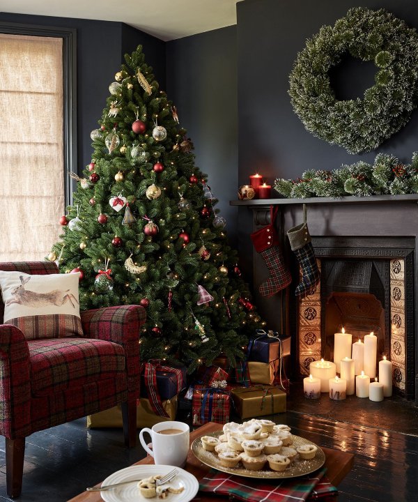 Árvore de natal com neve branca com decoração de presentes no interior da  casa de ano novo