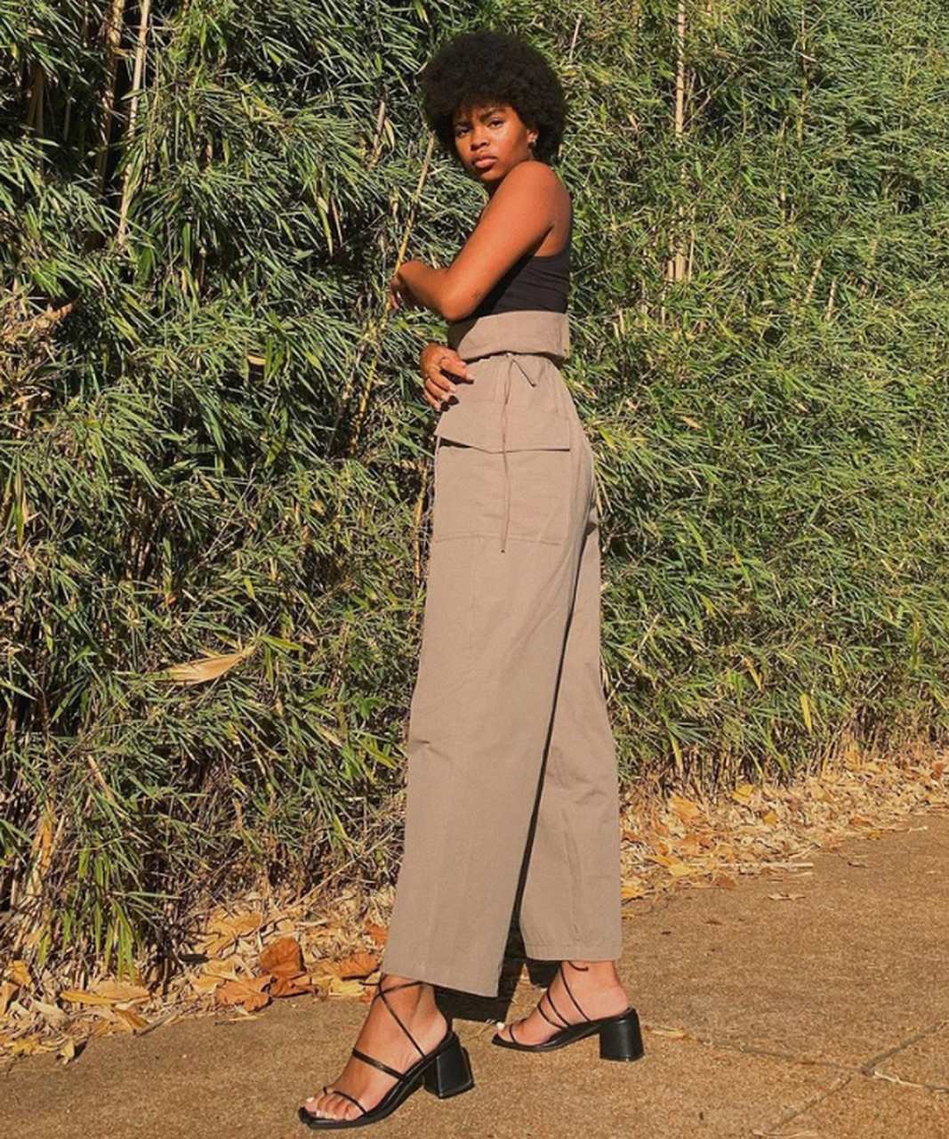 Samantha E. - blusa preta e calça pantacourt com sandália preta de salto baixo - sandálias confortáveis - Verão - perto de plantas - https://stealthelook.com.br